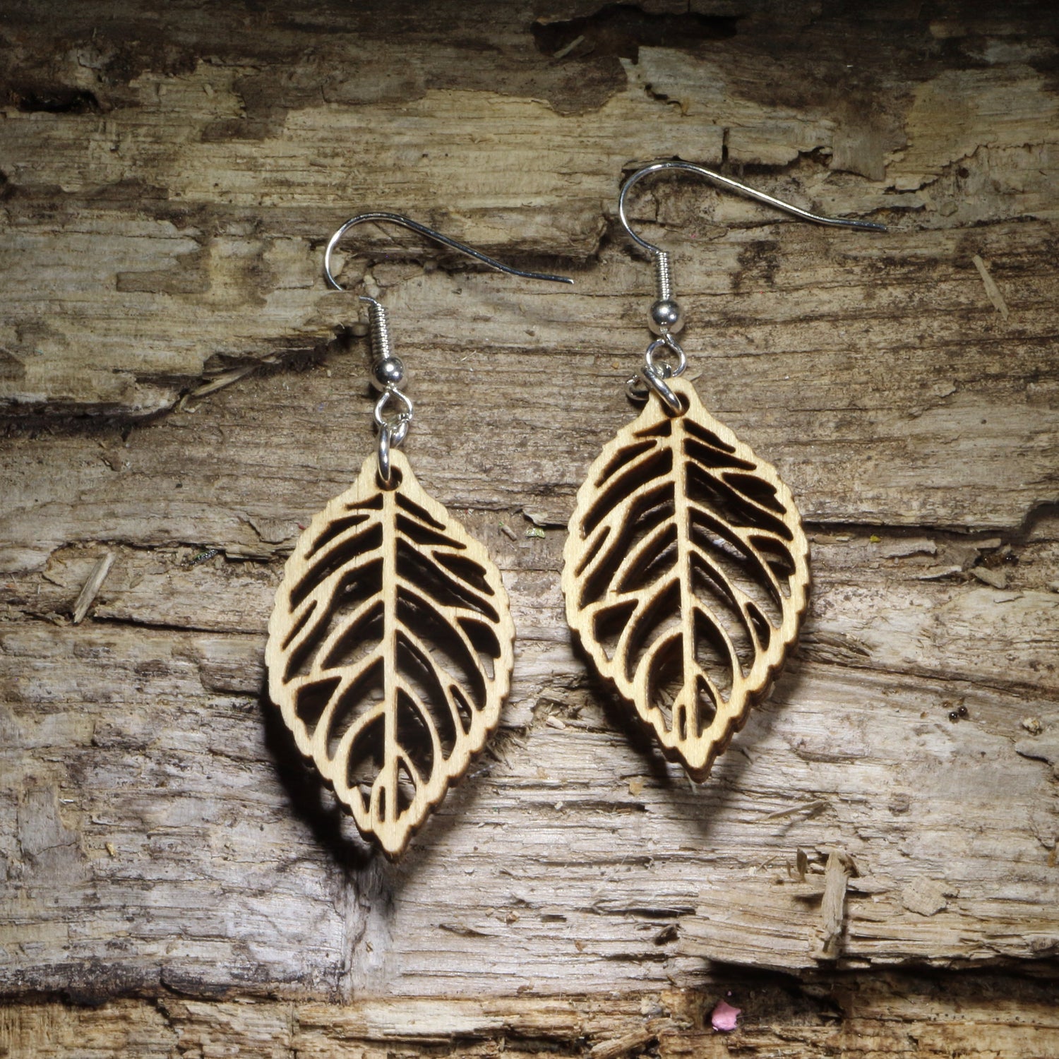 Handcrafted skeleton leaf wooden dangle earrings featuring an intricate laser-cut leaf vein design in natural Baltic birch wood. Lightweight wooden earrings with hypoallergenic .925 sterling silver hooks, perfect for nature lovers, botanical jewelry fans, woodland style, fall fashion, eco-friendly accessories, and handmade leaf earrings.