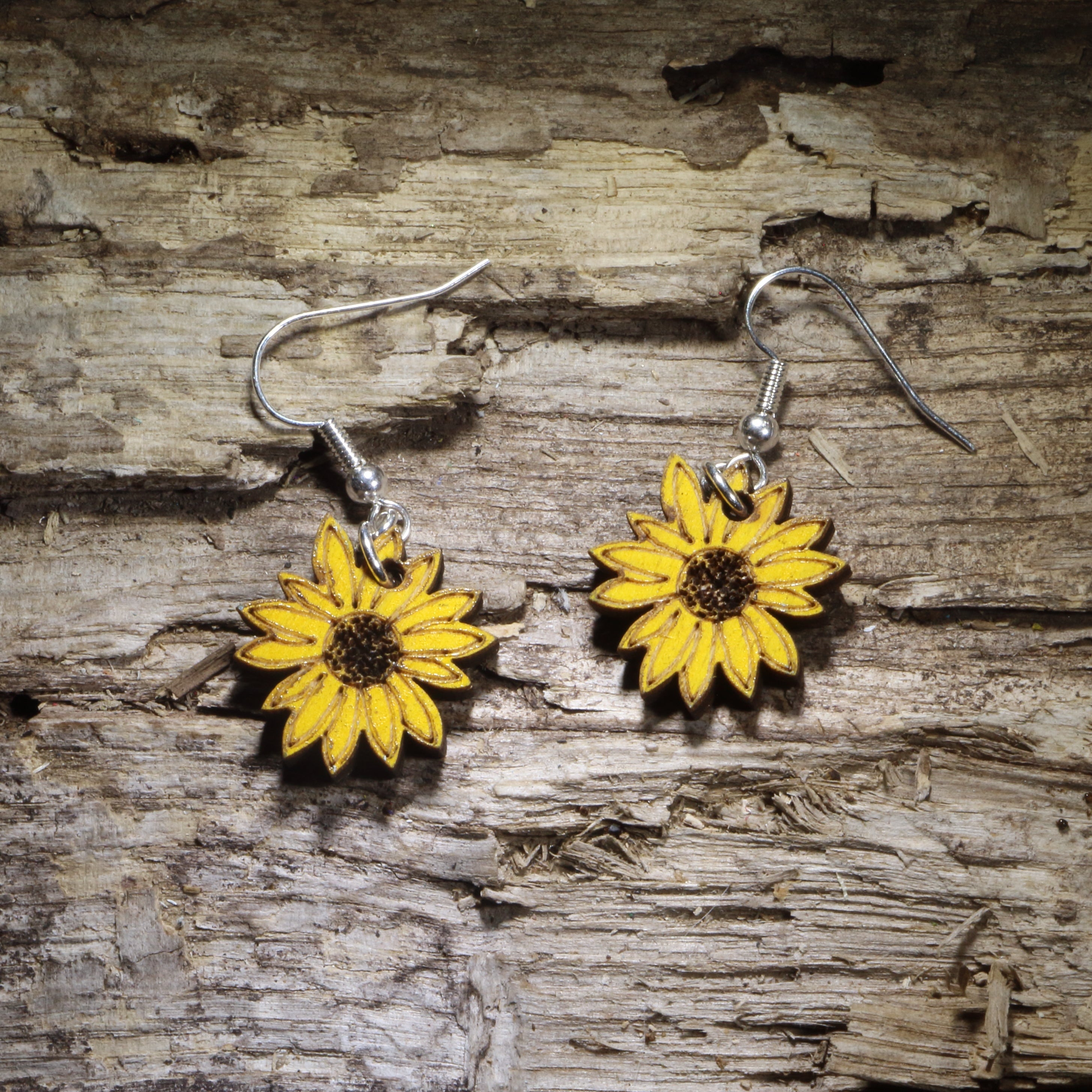 Handcrafted sunflower wooden dangle earrings featuring vibrant hand-painted yellow sunflower blooms with detailed brown centers. Lightweight laser-cut wooden earrings with hypoallergenic .925 sterling silver hooks, perfect for sunflower lovers, gardeners, cottagecore style, nature enthusiasts, summer fashion, floral gifts, and handmade botanical jewelry.