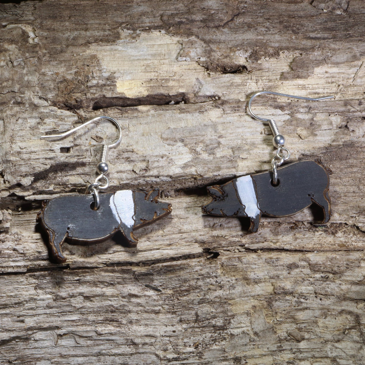 Handmade Hampshire pig wooden dangle earrings featuring detailed laser-cut black Hampshire pigs with signature white shoulder belt markings. Lightweight farm animal earrings crafted from wood with hypoallergenic .925 sterling silver hooks, perfect for pig lovers, farmers, livestock enthusiasts, 4-H and FFA members, homesteaders, and country lifestyle jewelry collectors.