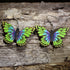 Handmade green and purple butterfly wooden dangle earrings featuring vibrant hand-painted butterfly wings with detailed laser-cut accents. Lightweight butterfly earrings crafted from wood with hypoallergenic .925 sterling silver hooks, perfect for butterfly lovers, nature enthusiasts, gardeners, insect fans, and colorful wildlife jewelry collectors.
