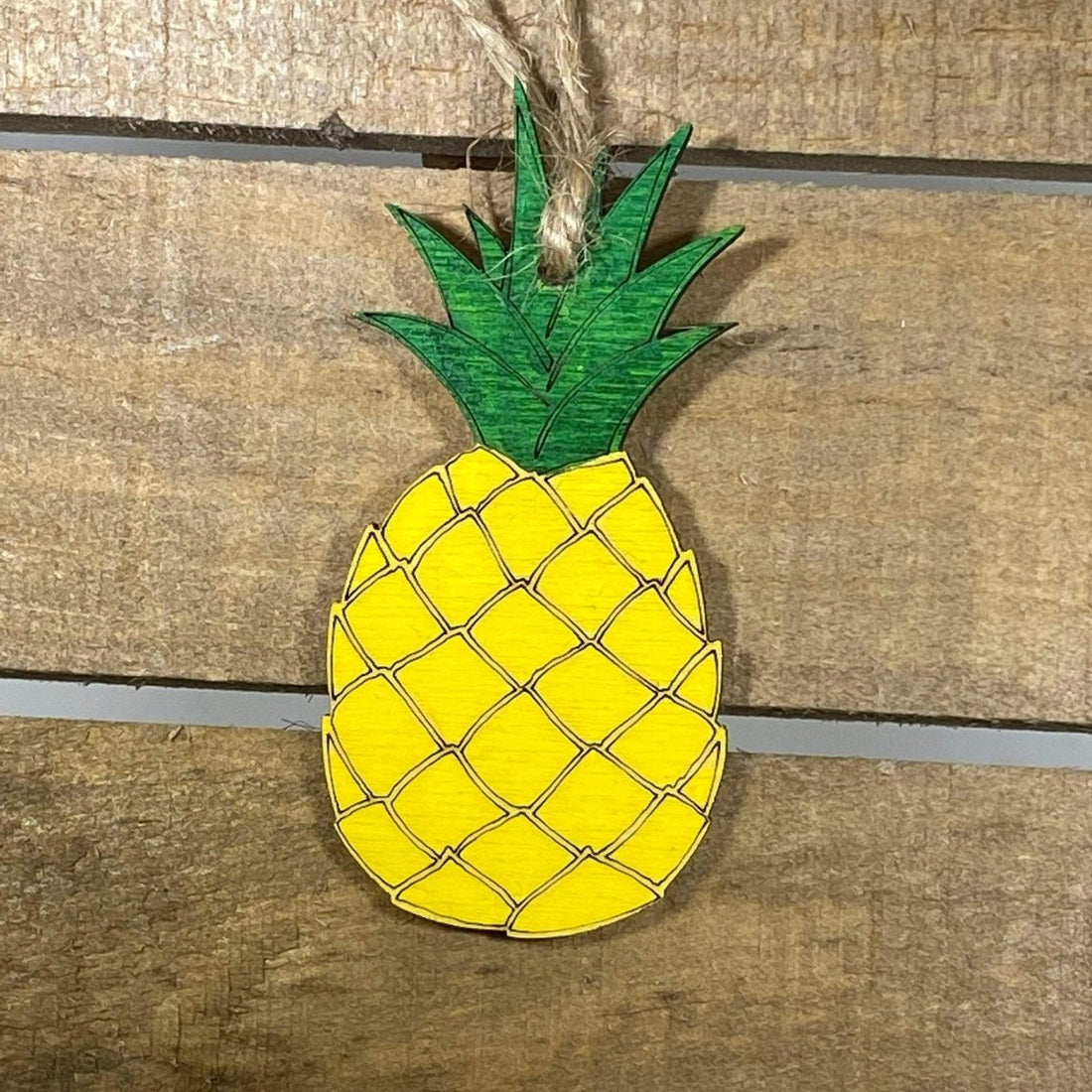 Hand-painted wooden Hawaiian pineapple Christmas ornament featuring a detailed tropical fruit design with textured pattern and leafy crown, festive holiday decor for beach lovers and tropical style enthusiasts by Cate’s Concepts