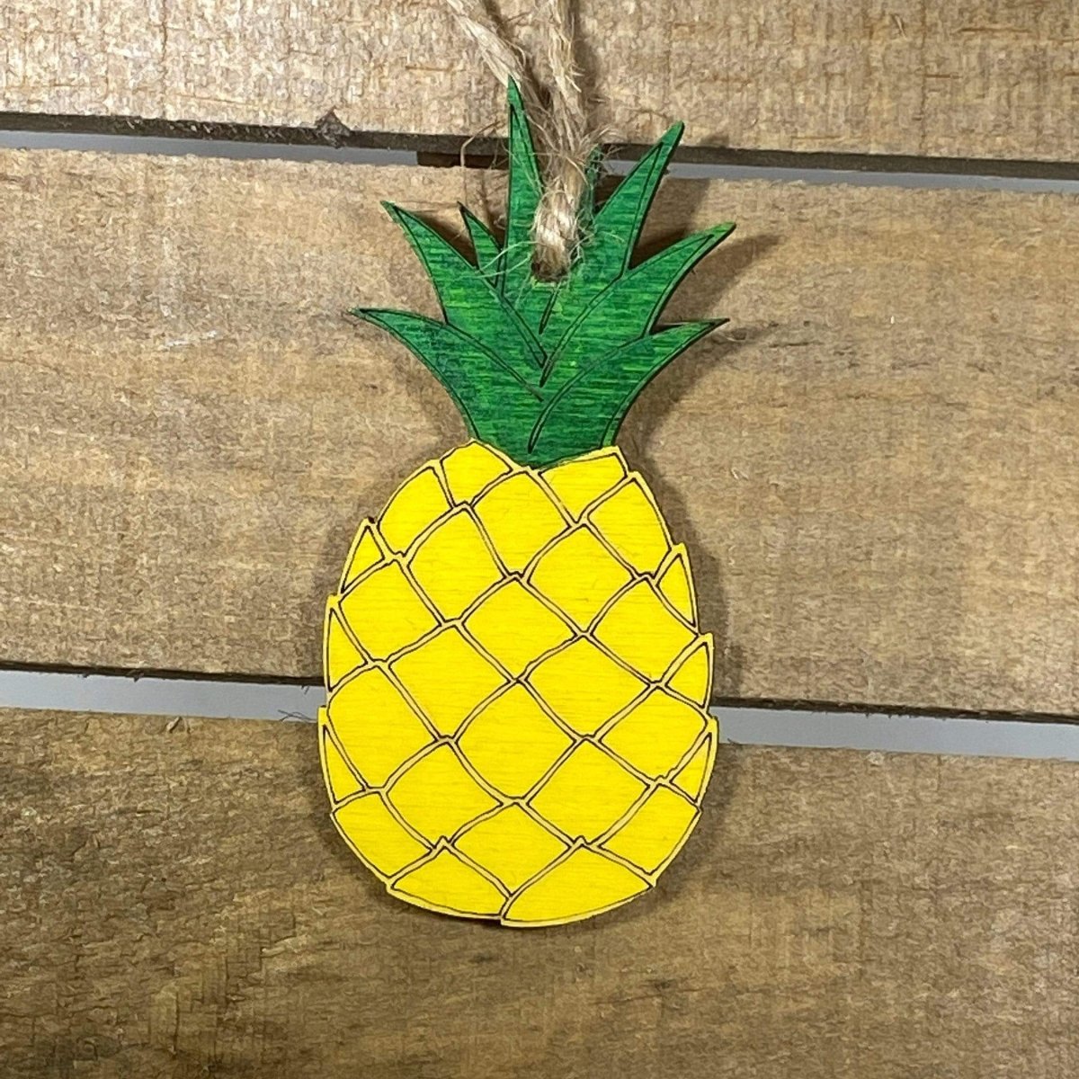 Hand-painted wooden Hawaiian pineapple Christmas ornament featuring a detailed tropical fruit design with textured pattern and leafy crown, festive holiday decor for beach lovers and tropical style enthusiasts by Cate’s Concepts