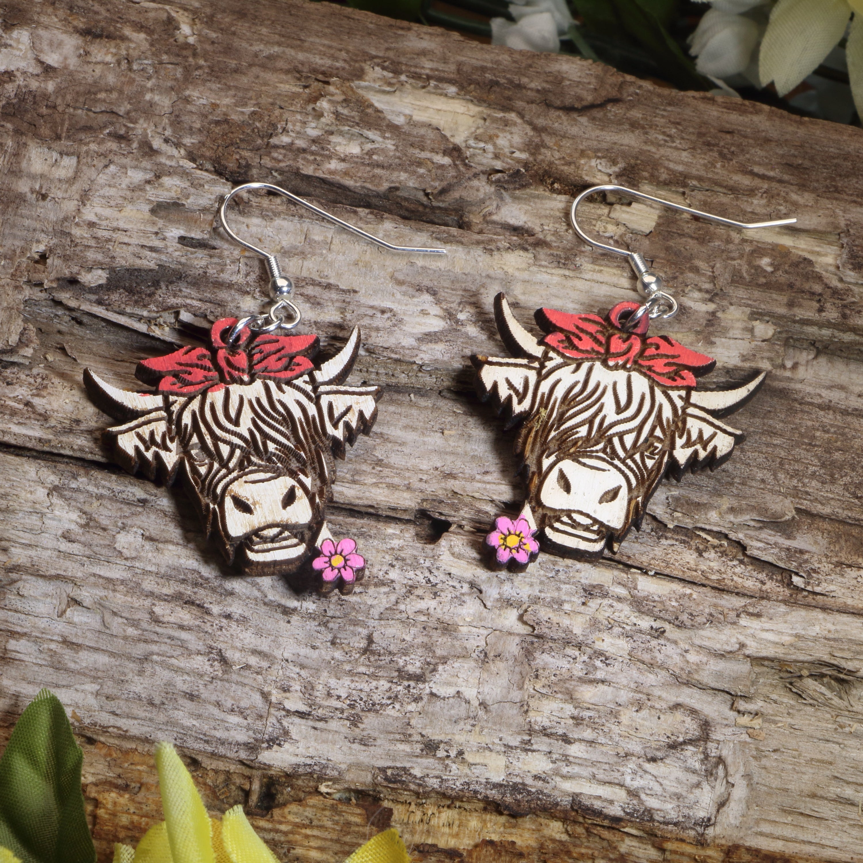 Hand-painted wooden Highland cow with flower dangle earrings featuring a charming farm animal design and hypoallergenic sterling silver hooks, lightweight western jewelry for cow lovers and rustic country style by Cate’s Concepts