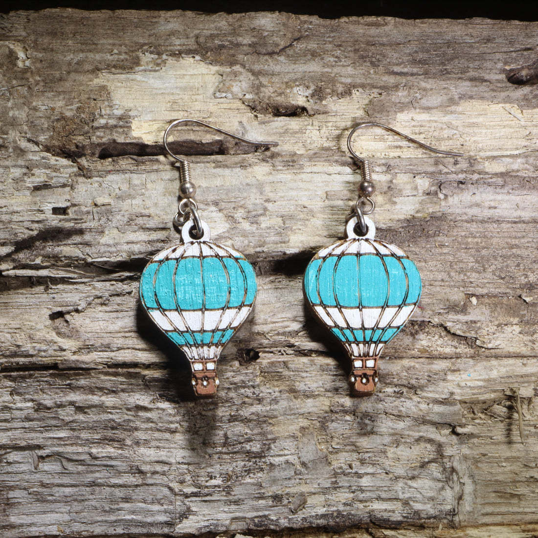 Handcrafted hot air balloon wooden dangle earrings featuring colorful hand-painted hot air balloons with engraved details. Lightweight laser-cut wooden earrings with hypoallergenic .925 sterling silver hooks, perfect for travel lovers, adventure seekers, aviation enthusiasts, wanderers, and unique handmade statement jewelry.