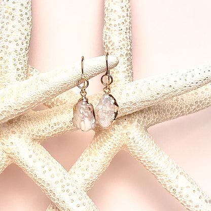ocean springs organic shape oval drop pearl earrings on pink background with sea stars