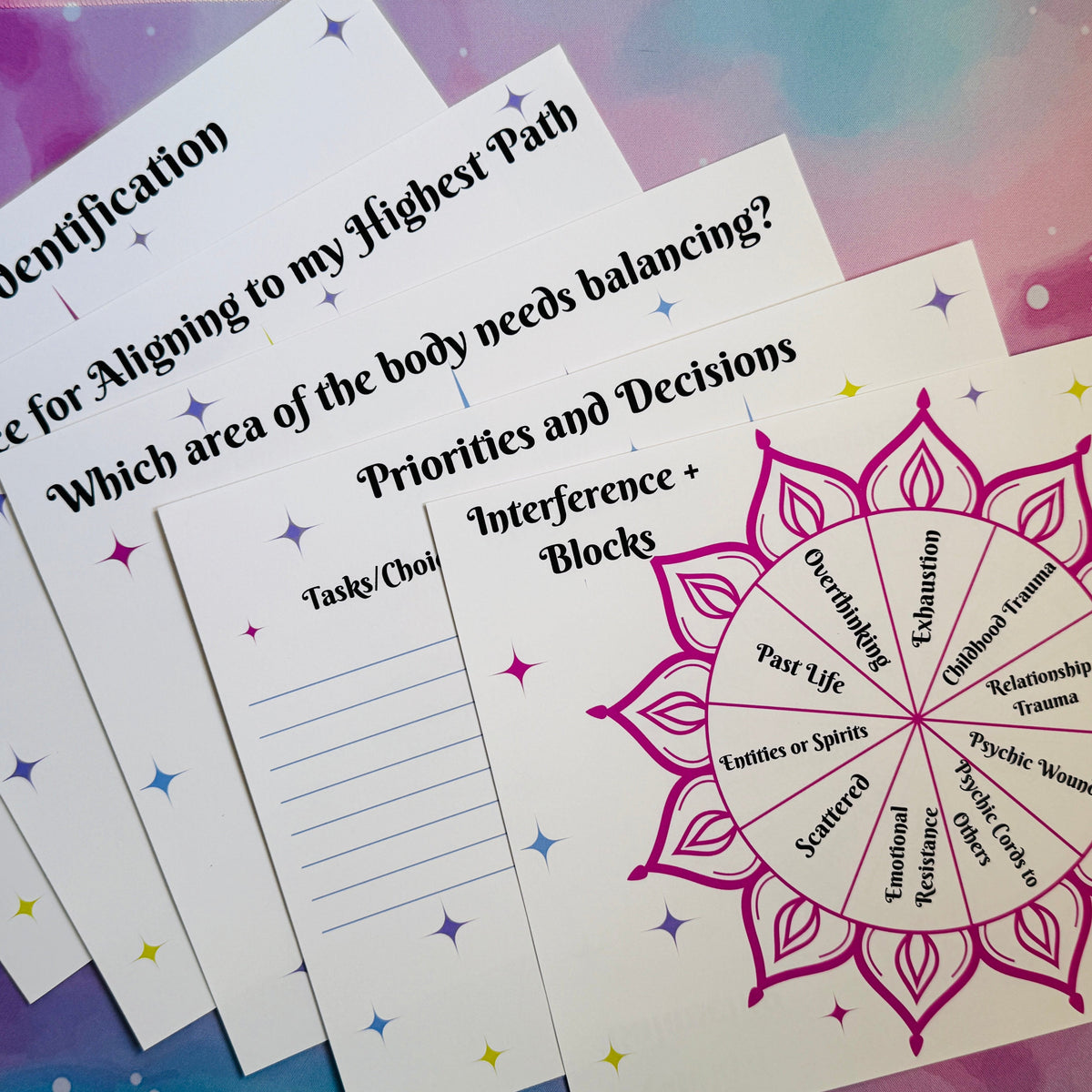 A set of printed spiritual guidance cards fanned out on a colorful pastel background. The cards feature black text with headings like &