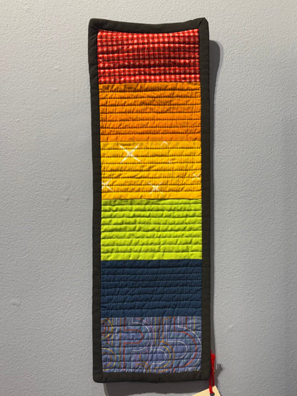 Colorful woven strip with a pattern on a gray surface