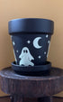 From the dark of night, the moon appears and casts a haunted glow. Perfect for a haunted garden, this black planter is made complete with 4 cute spooky ghosts, stars and a crescent moon to enhance your decor. 