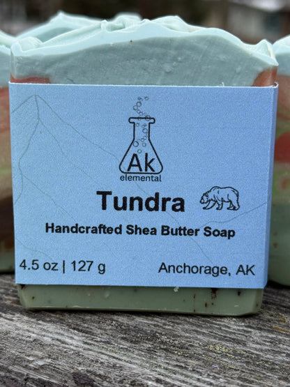 Rectangular soap bar with avocado oil, coconut milk, and bear embed, styled outdoors in snowy Alaska setting