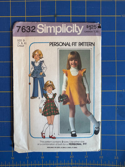Simplicity 7632 personal fit sewing pattern envelope for children, featuring illustrations of three girls in different outfits, placed on a blue grid cutting mat.