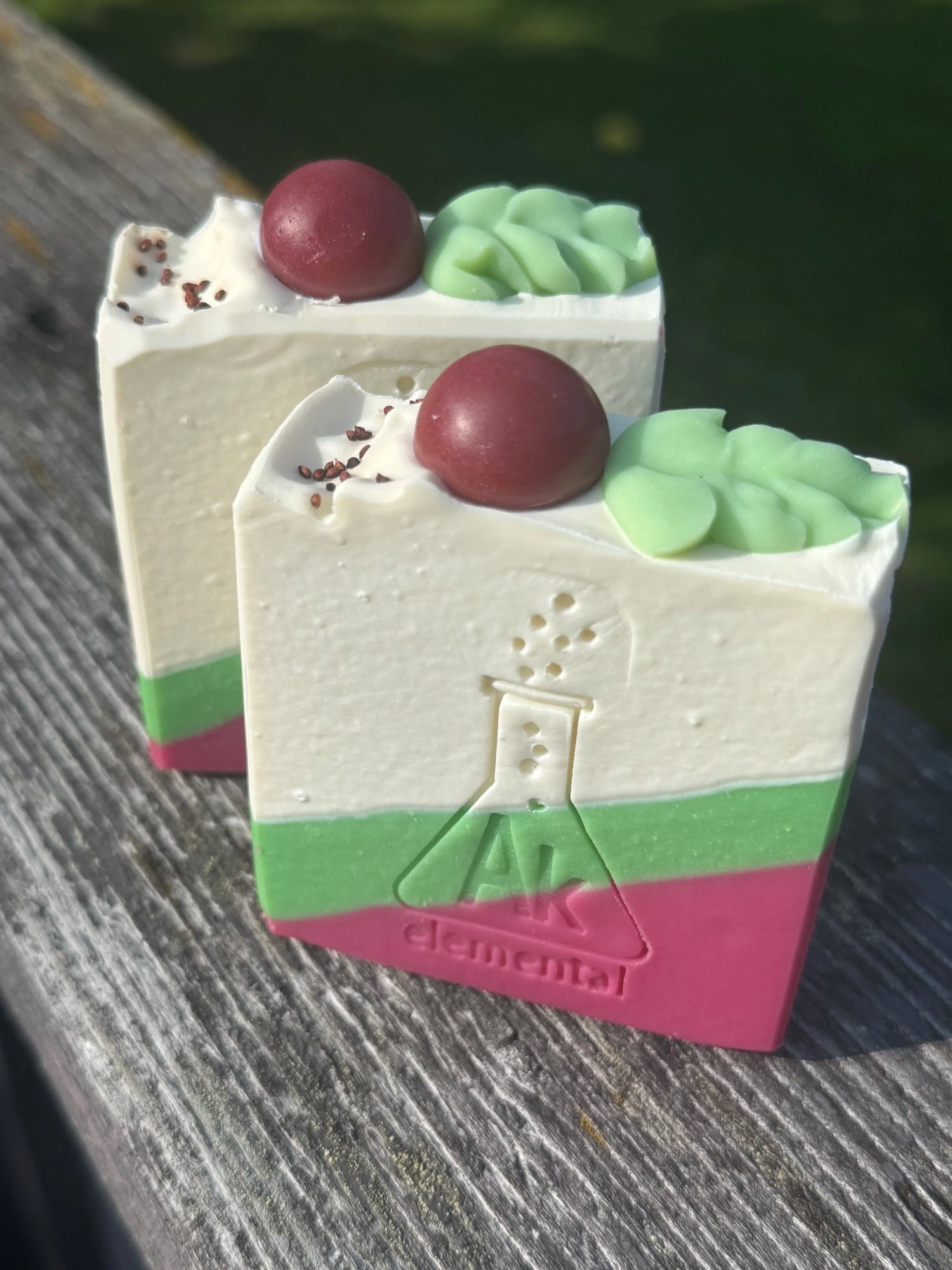 Handcrafted Wild Cranberry soap bar with cream, evergreen green and cranberry red diagonal layers and festive round soap embeds on top.
