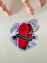 A die-cut sticker featuring a red coffin with a black band, black pentagram, white skeleton hand, crescent moon, scythe, and a black banner reading &