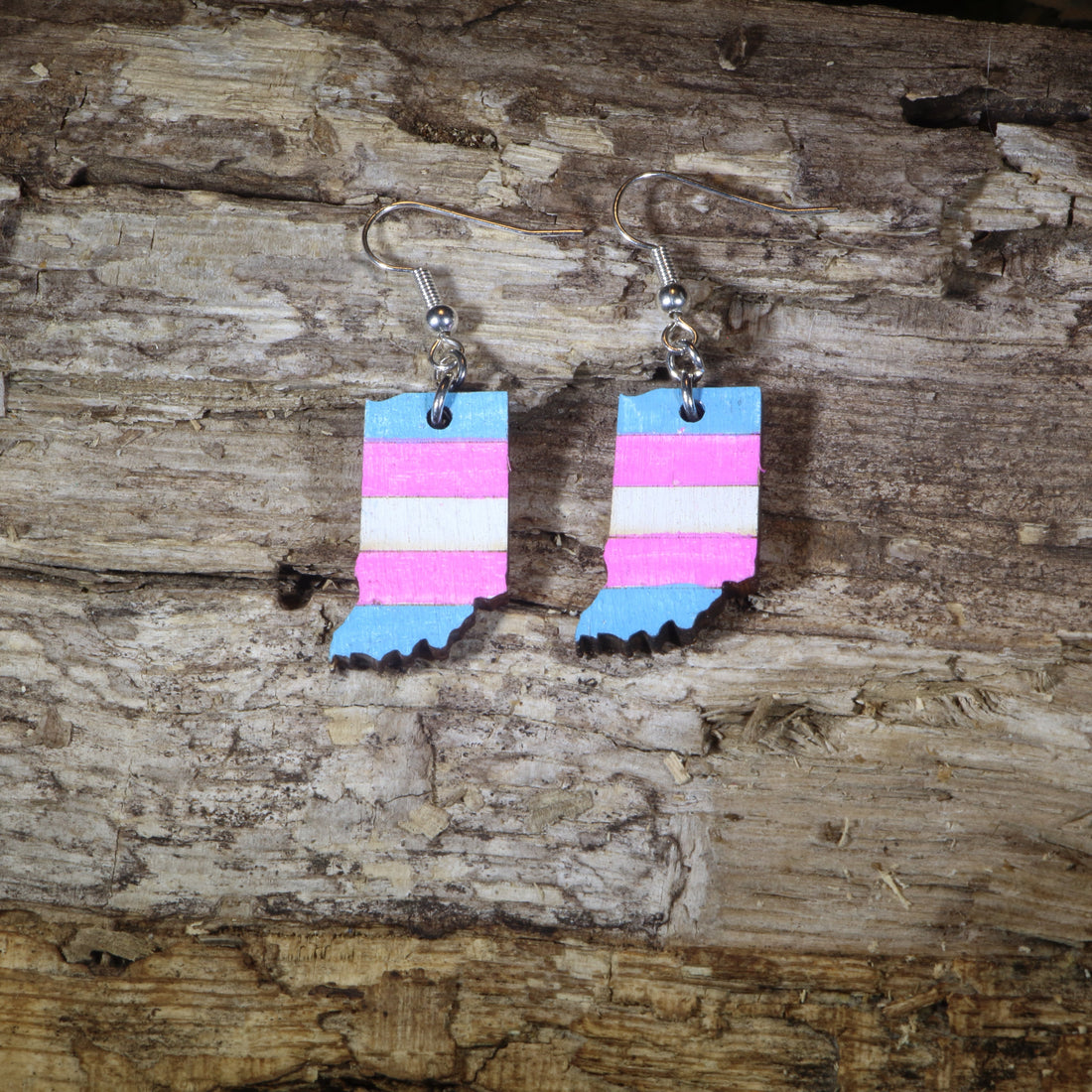 Hand-painted wooden Indiana transgender pride dangle earrings featuring the Indiana state silhouette with pink, blue, and white transgender pride stripes, hypoallergenic sterling silver hooks, and lightweight LGBTQ+ state pride jewelry by Cate&