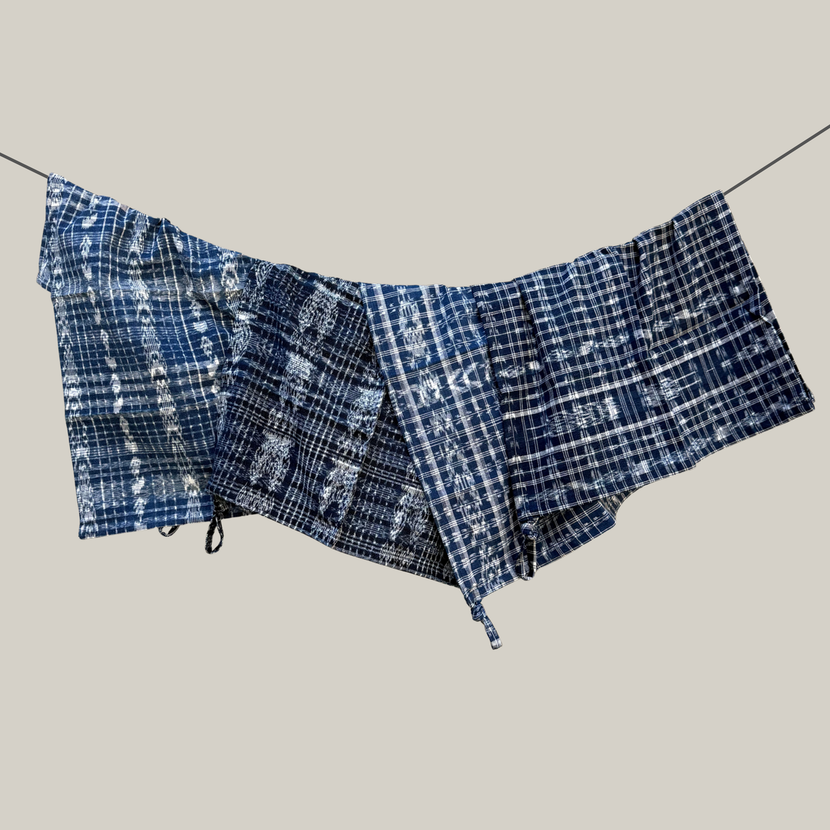 Blue and white handwoven ikat dish towels on a gray background