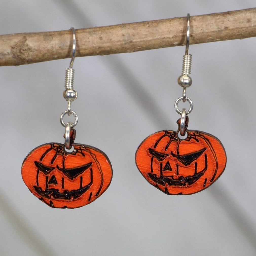 Hand-painted wooden jack-o-lantern dangle earrings with spooky Halloween pumpkin design and hypoallergenic sterling silver hooks, lightweight pumpkin statement jewelry earrings for fall festivals and haunted season style
