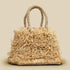Fair trade Beige raffia hand woven trapezoid mini handbag with looped fringe on a beige background