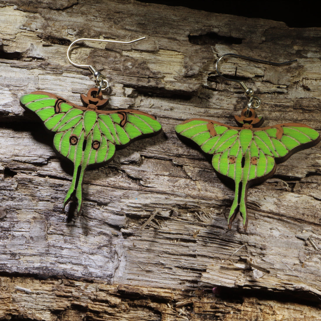 Hand-painted wooden Luna moth dangle earrings featuring the iconic green luna moth with delicately detailed wings and long tails. Lightweight wooden earrings with hypoallergenic .925 sterling silver hooks, perfect for moth lovers, nature enthusiasts, entomologists, and anyone who appreciates woodland-inspired jewelry.