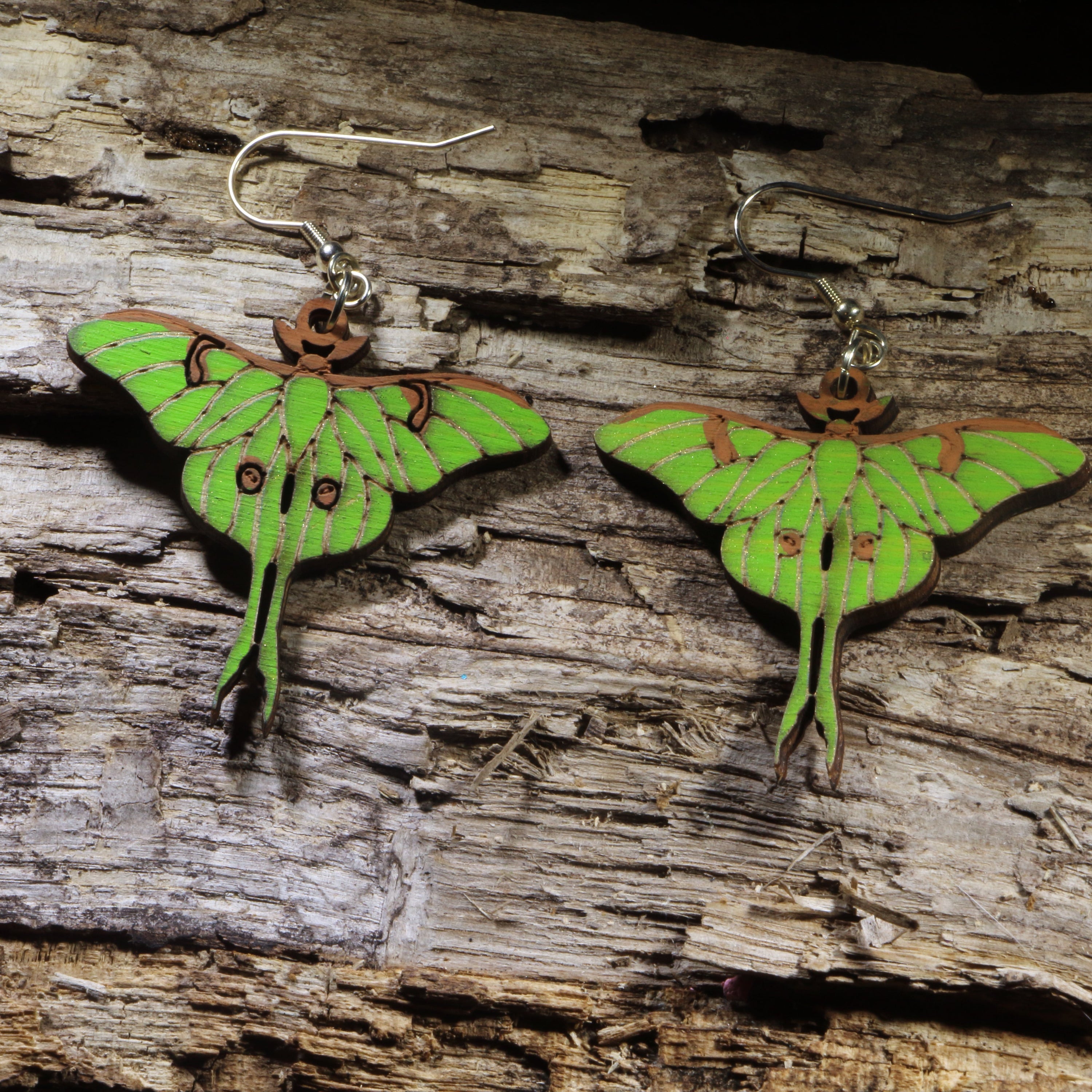 Hand-painted wooden Luna moth dangle earrings featuring the iconic green luna moth with delicately detailed wings and long tails. Lightweight wooden earrings with hypoallergenic .925 sterling silver hooks, perfect for moth lovers, nature enthusiasts, entomologists, and anyone who appreciates woodland-inspired jewelry.