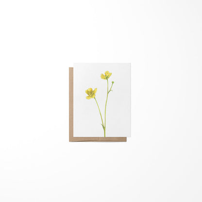 A greeting card with a buttercup flower illustration on the front, made from heavy paper stock, with a blank inside for a message.
