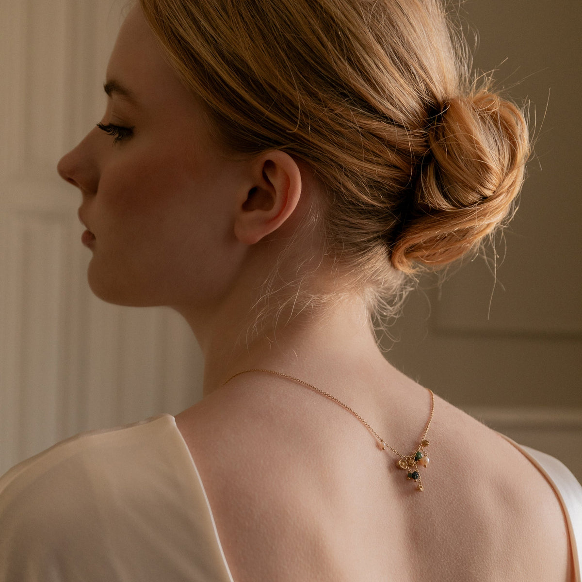 gold artisan necklace, worn backwards on model