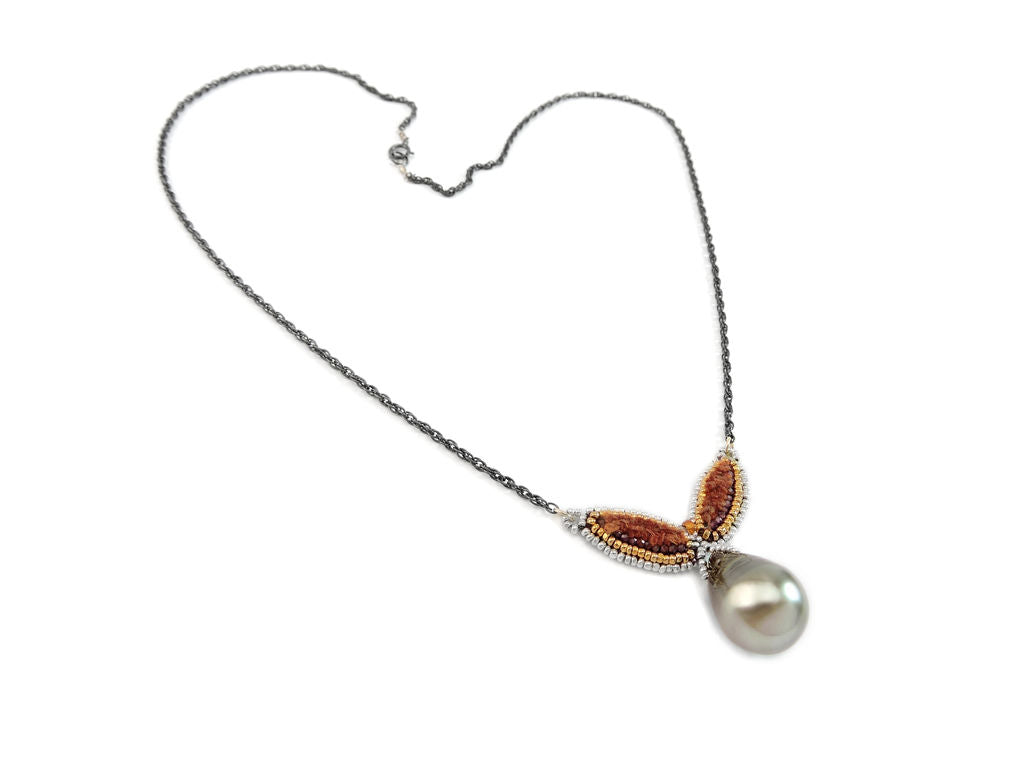 A silver chain necklace with hand sewn petals of silk strands and silver and gold beads on leather featuring a pearl pendant , made ethically in Mexico