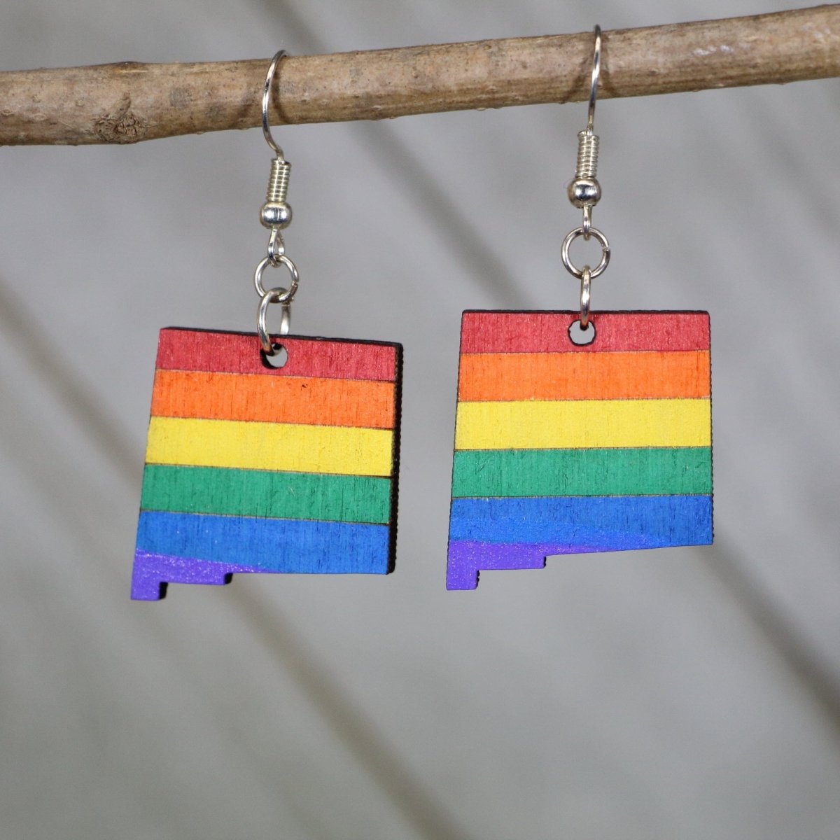 Hand-painted wooden New Mexico LGBTQ+ pride dangle earrings with Zia sun symbol rainbow design and hypoallergenic sterling silver hooks, lightweight pride statement jewelry earrings for NM state pride and LGBTQ expression