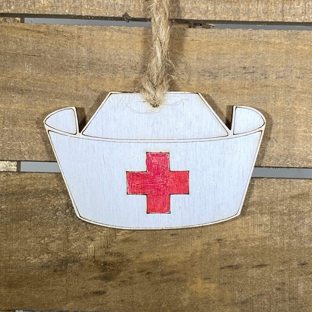 Hand-painted wooden nurse hat Christmas ornament featuring a classic white cap with red cross detail, thoughtful holiday decor for nurses and healthcare professionals by Cate’s Concepts