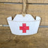 Hand-painted wooden nurse hat Christmas ornament featuring a classic white cap with red cross detail, thoughtful holiday decor for nurses and healthcare professionals by Cate’s Concepts
