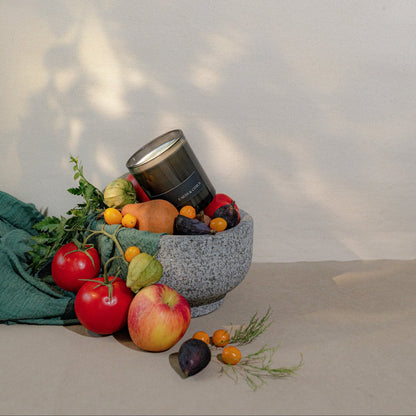 Fruit and vegetable display with a black container on a neutral background