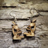 Pair of natural wood microscope dangle earrings featuring detailed scientific laboratory microscope designs, displayed on rustic weathered wood