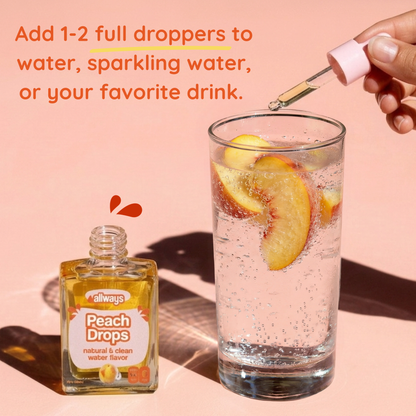 Peach Drops bottle with a glass of water and peach slices on a pink background