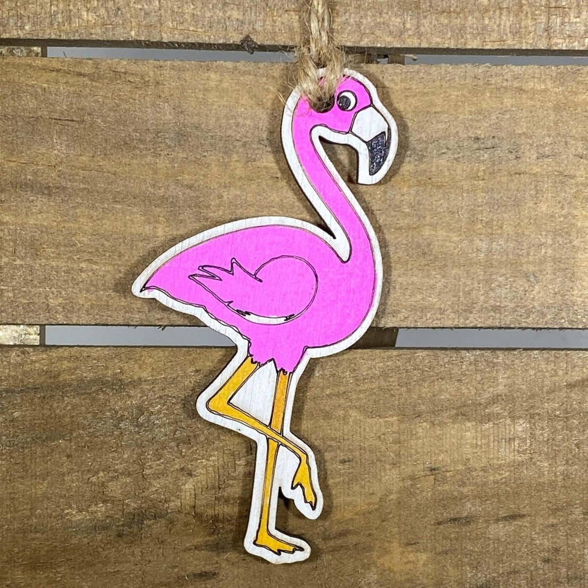 Hand-painted wooden pink flamingo Christmas ornament featuring a vibrant tropical bird design with curved neck and detailed feathers, festive holiday decor for beach lovers and tropical style enthusiasts by Cate’s Concepts