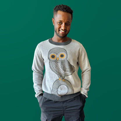 Person wearing the Owl on a Vowel light gray graphic knit sweater by Jedd — cozy original artist knitwear