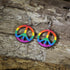 Hand-painted wooden rainbow peace sign dangle earrings featuring a colorful peace symbol design, hypoallergenic sterling silver hooks, and lightweight LGBTQ+ pride jewelry for peace lovers, festival outfits, and rainbow accessory fans by Cate&