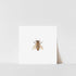 A square art print featuring a close-up image of a honey bee on a white background, with a white border and a signature in pencil at the bottom right corner.