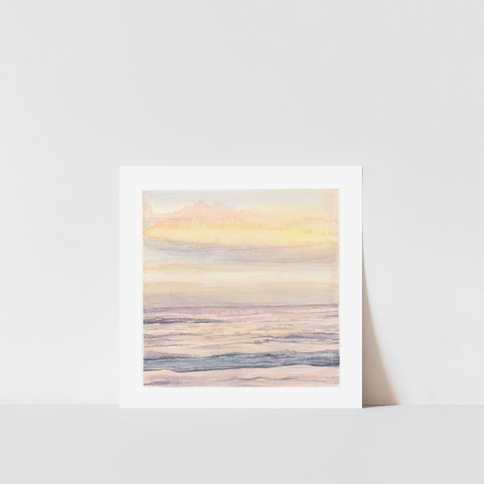 A framed art print of a dreamy sunset over a coastline, with soft colors and a serene atmosphere.