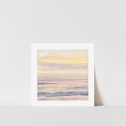 A framed art print of a dreamy sunset over a coastline, with soft colors and a serene atmosphere.