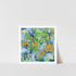 A framed art print featuring a watercolor painting of wildflowers with a blue background, displayed on a white shelf against a white wall.