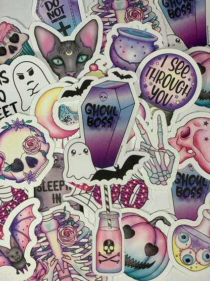 A mix of spooky, halloween, goth, and witchy stickers in shades of pastel and black