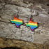 Hand-painted wooden Texas LGBTQ Pride dangle earrings featuring the Texas state silhouette with vibrant rainbow pride stripes, hypoallergenic sterling silver hooks, and lightweight LGBTQ+ state pride jewelry by Cate&