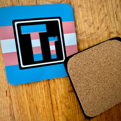 The Trans Element coaster. On the left is the front of the Trans element with the colors of the Trans flag. On the right is te back of our coasters, which have cork across the back of the coaster. 