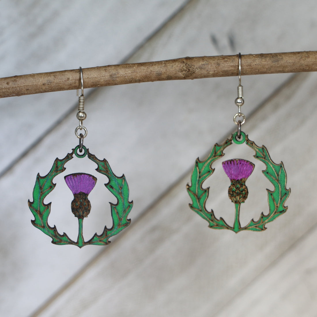 Hand-painted wooden thistle dangle earrings with Celtic Scottish flower design and hypoallergenic sterling silver hooks, lightweight botanical jewelry for heritage lovers and nature-inspired style by Cate’s Concepts
