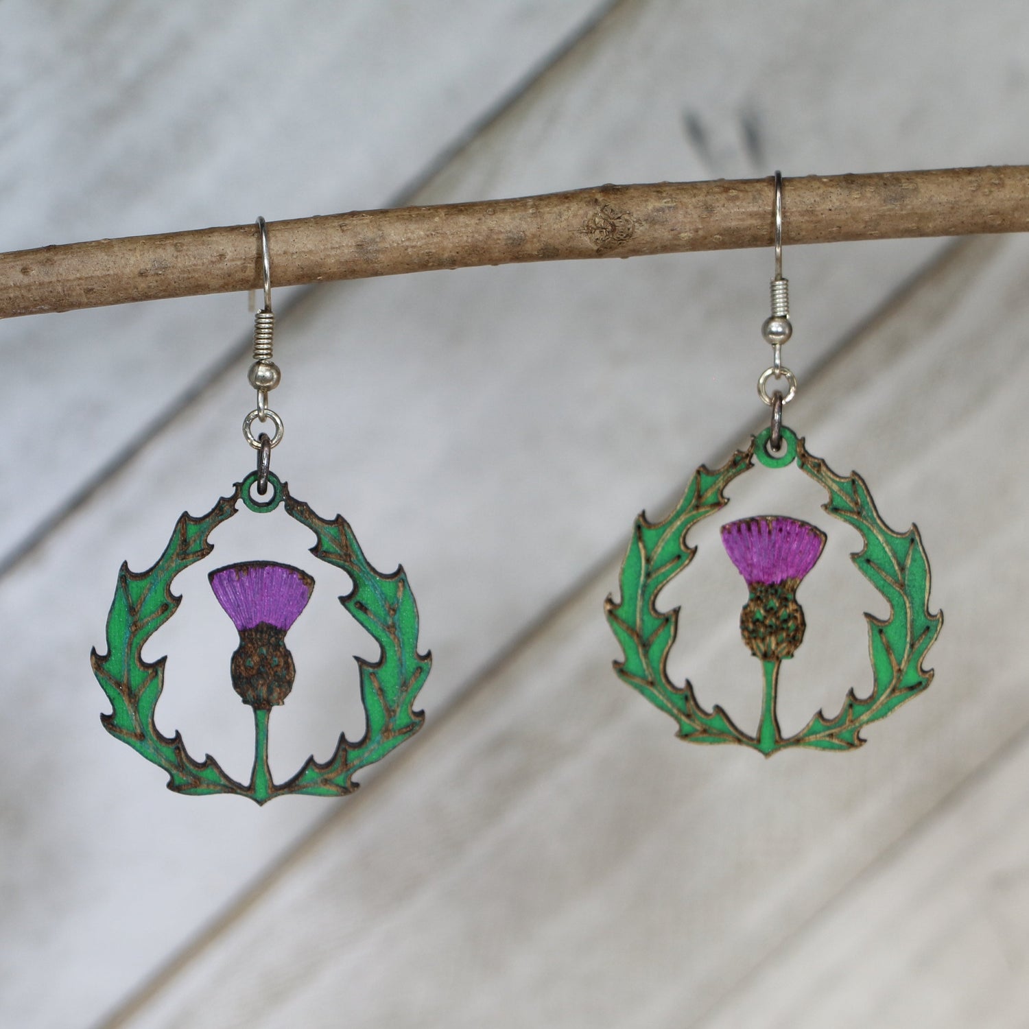 Hand-painted wooden thistle dangle earrings with Celtic Scottish flower design and hypoallergenic sterling silver hooks, lightweight botanical jewelry for heritage lovers and nature-inspired style by Cate’s Concepts
