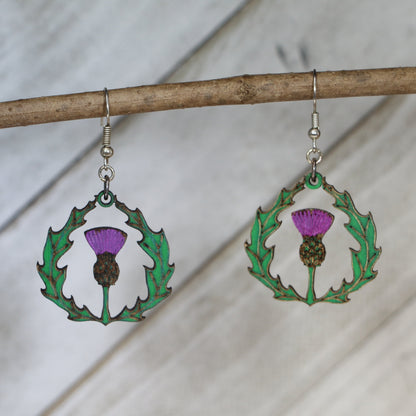 Hand-painted wooden thistle dangle earrings with Celtic Scottish flower design and hypoallergenic sterling silver hooks, lightweight botanical jewelry for heritage lovers and nature-inspired style by Cate’s Concepts
