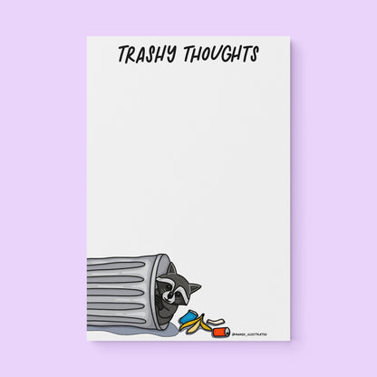 Trashy Thoughts raccoon notepad flat lay — funny trash panda notepad by indie artist MangoIllustrated