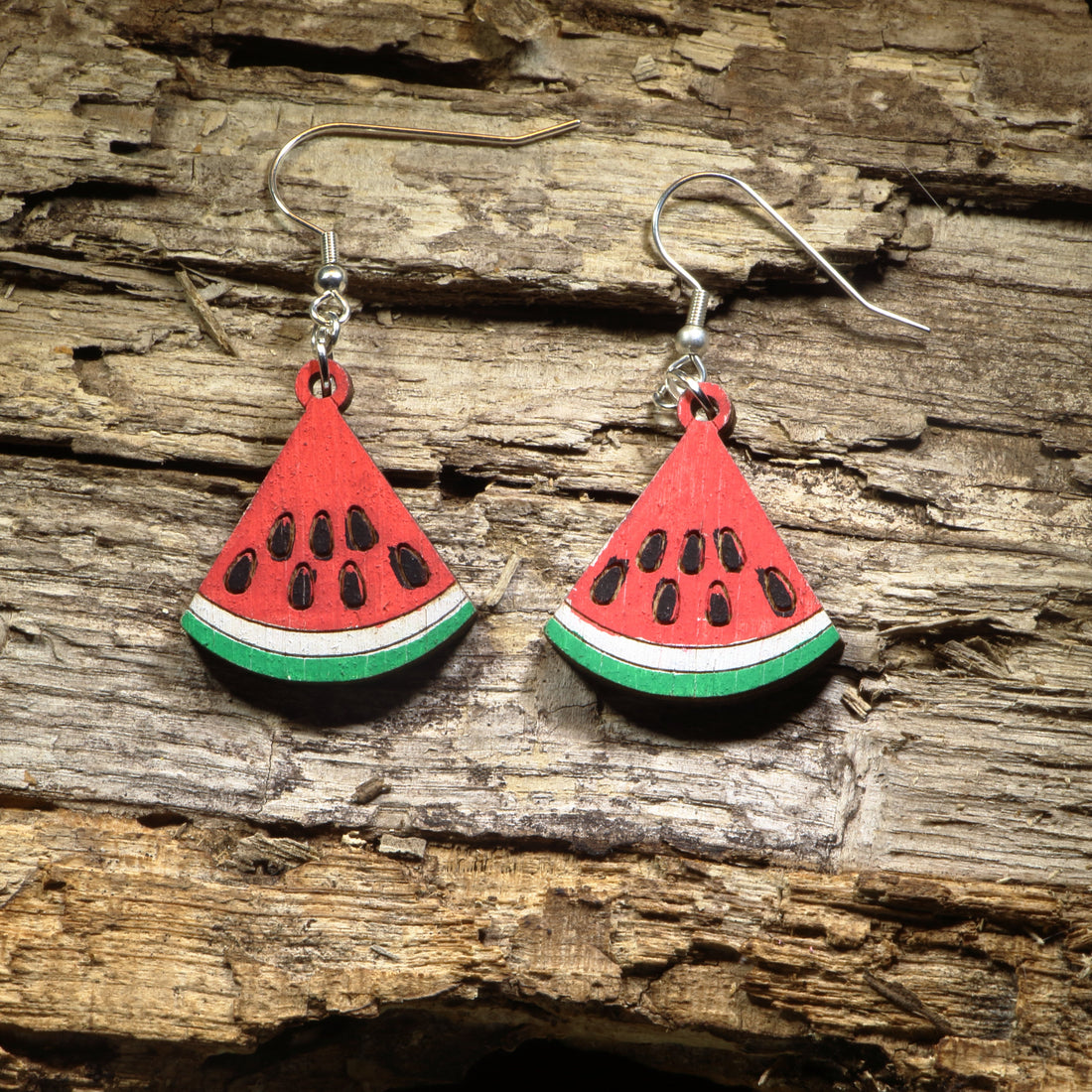 Hand-painted wooden watermelon slice dangle earrings featuring juicy watermelon wedges with vibrant red, green, and black seed details. Crafted from lightweight wood with hypoallergenic .925 sterling silver hooks, these cheerful earrings are perfect for summer fashion, fruit lovers, farmers markets, picnics, beach vacations, and anyone who enjoys playful food-inspired jewelry.