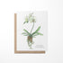 A greeting card featuring a white orchid with a quote on a white background, with a Kraft envelope.