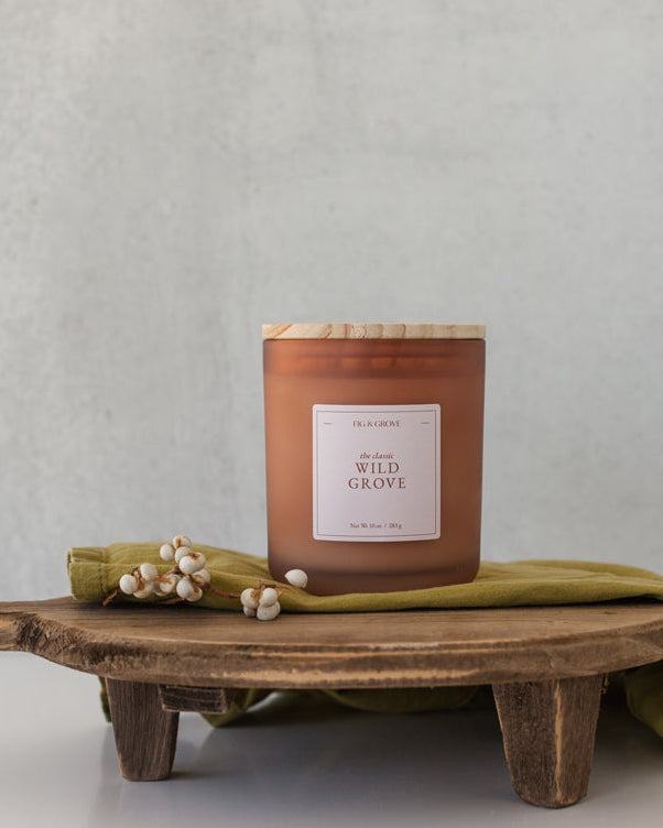 Wild Grove candle by Fig &amp; Grove, featuring a minimalist label and natural wax, with calming scents of palo santo, lavender, and sage.