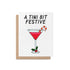 Illustrated holiday greeting card with a red martini, candy cane garnish, and holly, featuring the phrase "A Tini Bit Festive" in bold lettering.