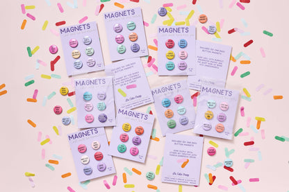 Colorful magnet sets with packaging on a pink background with sprinkles.